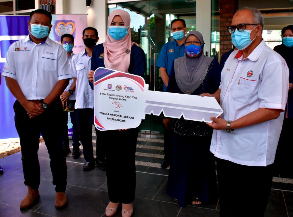 Women, Family and Community Development Minister Datuk Seri Rina Harun (centre) handing a replica a key to Better Brighter Anjung Kasih Yayasan Kebajikan Negara (YKN) Hospital Melaka to Melaka Health Director Datuk Dr Ismail Ali (right). - Bernama