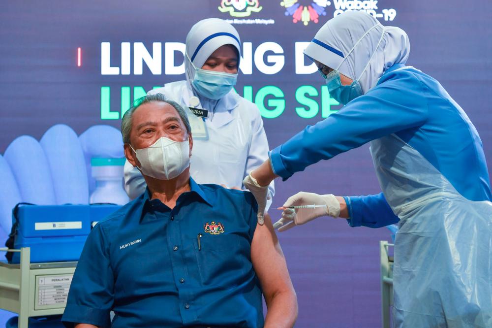 Prime Minister Tan Sri Muhyiddin Yassin is ready to receive the Pfizer BioNTech COVID-19 vaccine from Chief Nurse Lina Ibrahim at the Putrajaya District Health Office Precinct 11 on Feb 24. - Bernama