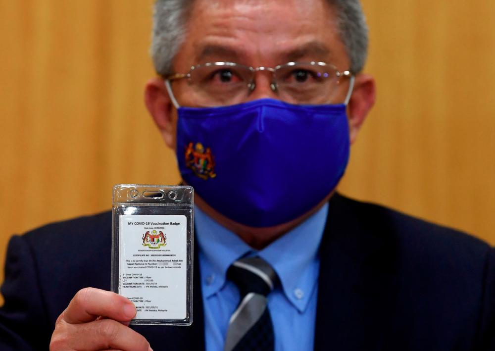Health Minister Datuk Seri Dr Adham Baba showing the MY COVID-19 Vaccination Badge during a joint press conference - Bernama
