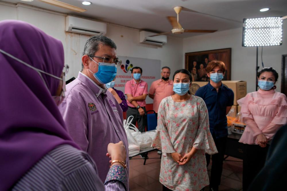 Communications and Multimedia Minister Datuk Saifuddin Abdullah having a light moment with the production crew and actors while attending a standard operating procedure (SOP) monitoring session at the filming location at Wangsa Maju Community activity center on March 20. - Bernama