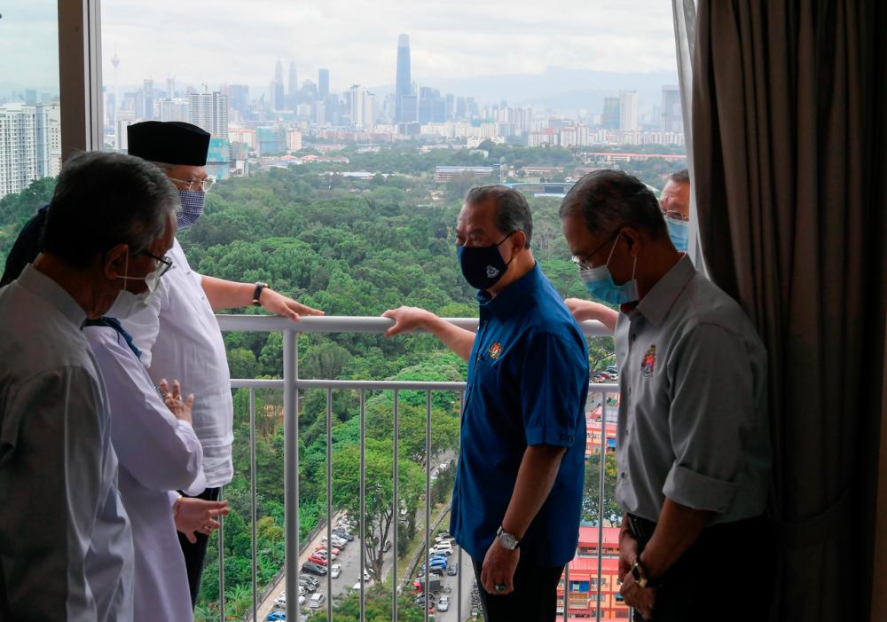 Perdana Menteri Tan Sri Muhyiddin Yassin melihat permandangan ibu kota dari balkoni rumah di Residensi Razakmas2 pada majlis penyerahan kunci kepada pemilik residensi tersebut hari ini. Turut sama Menteri Wilayah Persekutuan Tan Sri Annuar Musa (dua, kiri).-Bernama