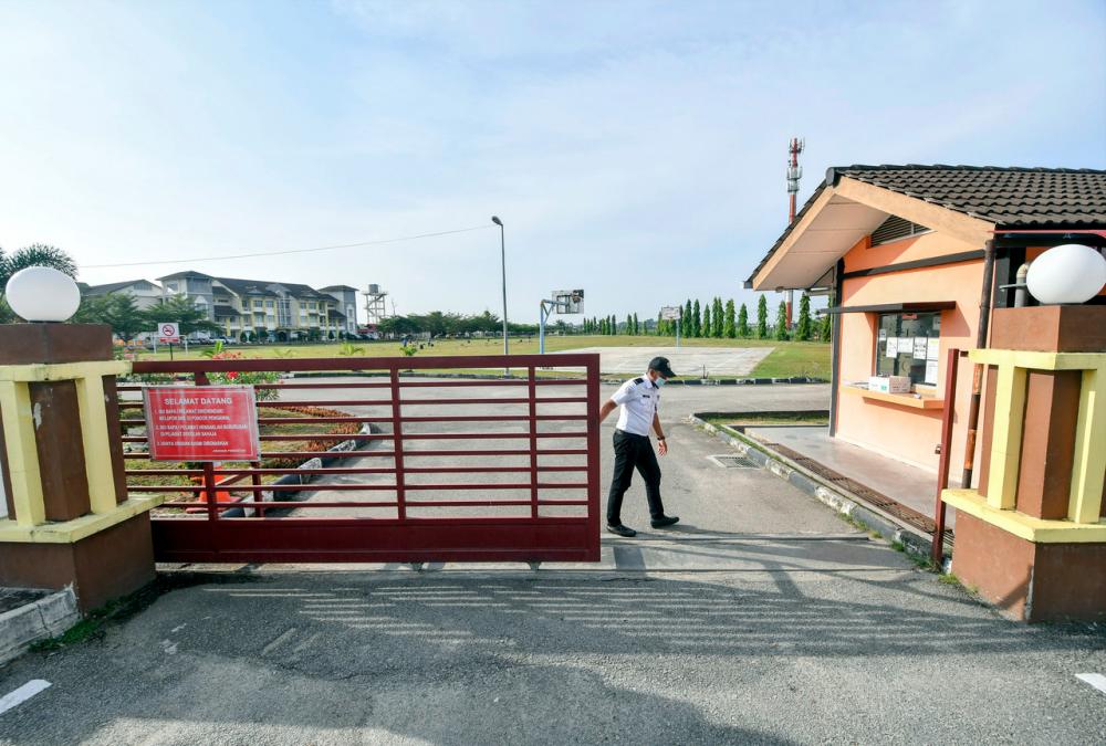 A school guard closing the main gate at Sekolah Menengah Kebangsaan Padang Enggang on April 18. - Bernama