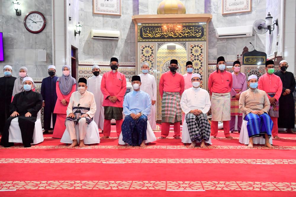 Prime Minister Tan Sri Muhyiddin Yassin poses with members of the highest committee of Al-Amaniah Jamek Mosque after performing the Isyak and Tarawih Prayers on April 19 - Bernama