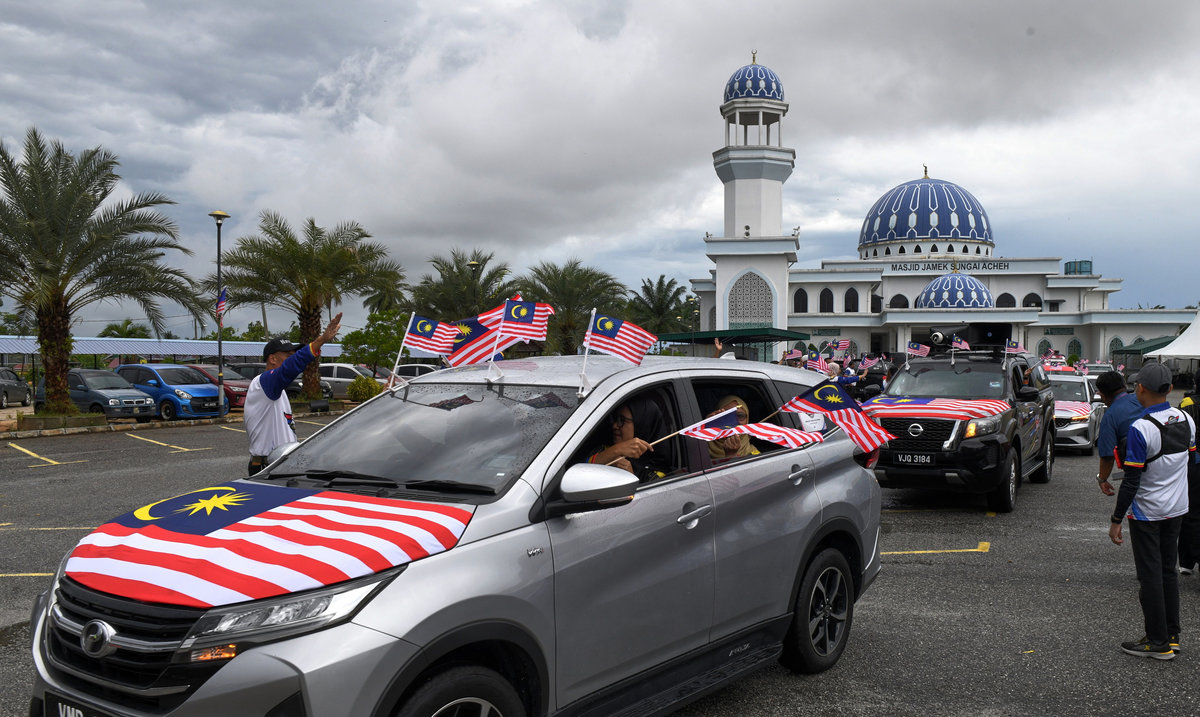 Participants of the Penang Kembara Merdeka Jalur Gemilang (KMJG) convoy continue their journey after receiving the Jalur Gemilang from the Perak participants at the compound of Sungai Acheh Mosque here today. – BERNAMA