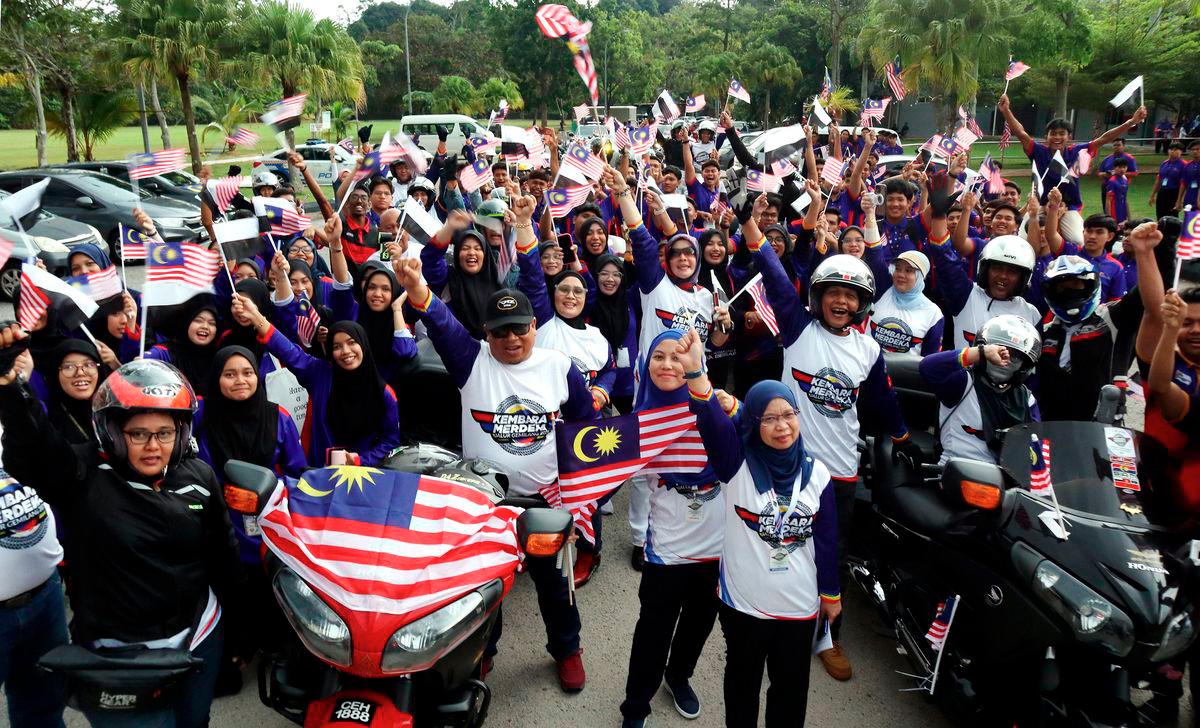 Pahang Information Department Director Rohani Chik (front) with participants and students chanting “Merdeka” three times before the flag-off of the state-level Kembara Merdeka Jalur Gemilang at Paya Besar Community College on August 12. – BERNAMA