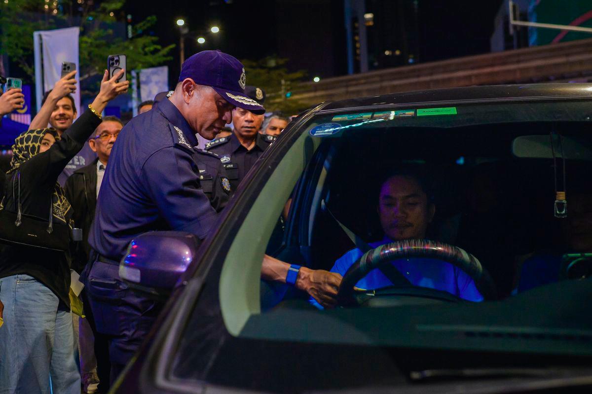 Kuala Lumpur Police Chief Datuk Fadil Marsus (left) issues a warning notice during the Law Compliance Operation (Op PUU) in Bukit Bintang on September 13, 2025. – BERNAMA