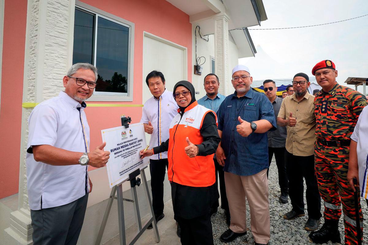 The Deputy Minister of Housing and Local Government, Datuk Aiman Athirah Sabu (third from left), signed a plaque in conjunction with the People’s Friendly Home (RMR) Key Handover Ceremony at the Clustered Land Development Scheme (RTB) Kampung Baru Kiri, Kemasik, today. Also present were the Chairman of the State Committee on Local Government, Housing and Health, Datuk Wan Sukairi Wan Abdullah (third from right), and the Chairman of Syarikat Perumahan Negara Berhad (SPNB), Prof Datuk Dr Mohd Azmi Mohd Lila (second from left). – BERNAMA
