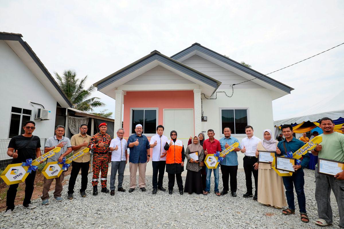 Timbalan Menteri Perumahan dan Kerajaan Tempatan, Datuk Aiman Athirah Sabu (tengah) bergambar bersama penerima kunci Rumah Mesra Rakyat (RMR) pada Majlis Penyerahan Kunci RMR di Rancangan Tanah Berkelompok (RTB) Kampung Baru Kiri, Kemasik, hari ini- BERNAMA