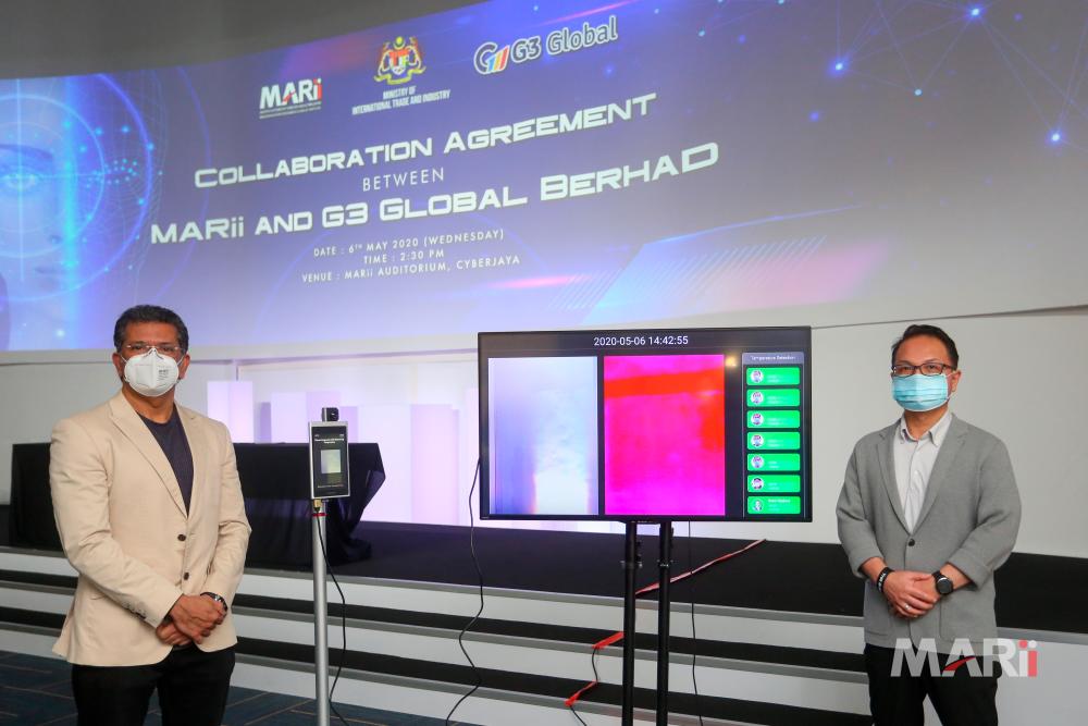 Khan (left) and Madani posing with the SenseTime Thunder-E thermal scanner and face recognition system