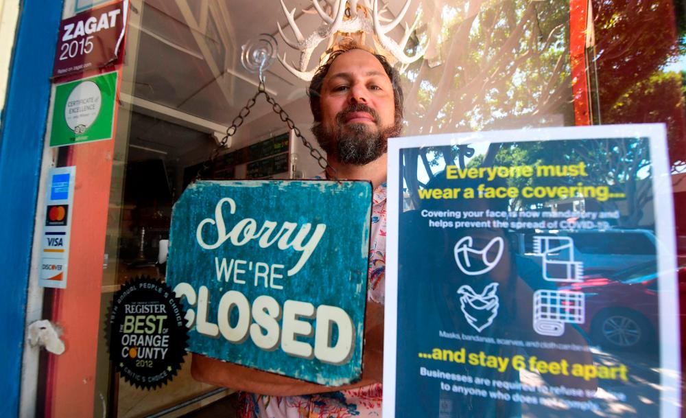 Gordon stands behind the entrance to his restaurant Beachwood BBQ, open for 14 years in Seal Beach, California, on July 28, 2020, but closing soon due to the economic situation around the coronavirus pandemic. – AFPPIX