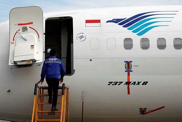A technician prepares to check Garuda Indonesia’s Boeing 737 Max 8 airplane parked at the Garuda Maintenance Facility AeroAsia — Reuters