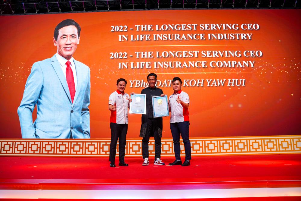 Dato Koh (middle) receiving the awards from The Malaysia Book of Records executives during the event.