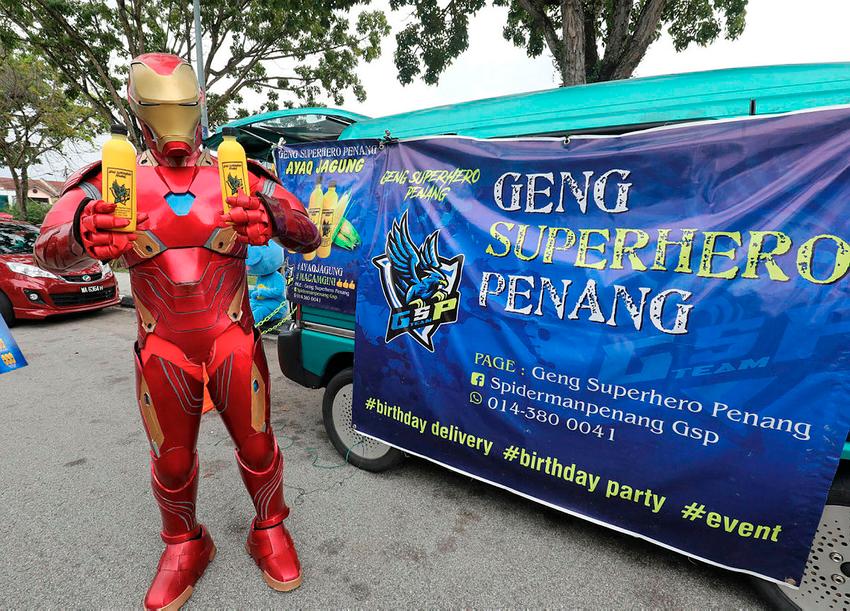 $!CAREER CHANGE ... Mohamad Syukur Mohd Patti, who recently lost his job, now assumes the persona of Ironman to sell corn flavoured drinks from the back of his van in Penang. – MASRY CHE ANI/THESUN