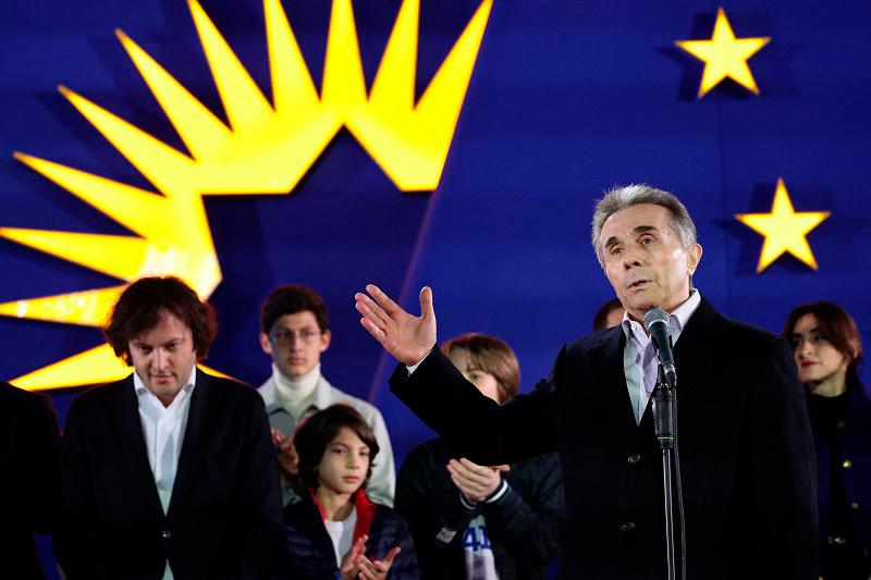 Georgian oligarch and founder of the ruling Georgian Dream party Bidzina Ivanishvili gives a speech as Georgian Prime Minister Irakli Kobakhidze stands behind during a gathering at the Georgian Dream party’s headquarters after exit polls were announced during parliamentary elections in Tbilisi on October 26, 2024. - Giorgi ARJEVANIDZE / AFP