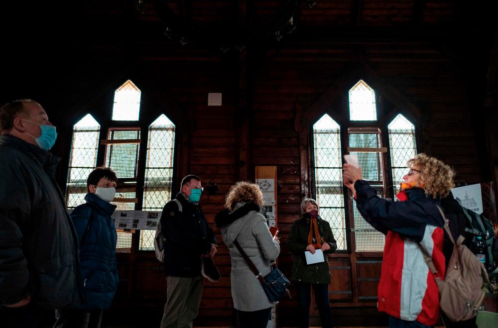 $!Tourists visit the Stabkirche, a stave church built in 1905 as part of the “Albert House” sanatorium for patients with lung diseases, in a wooded area outside the town of Stiege, Saxony-Anhalt, eastern Germany, on November 19, 2020. AFP / John MACDOUGALL