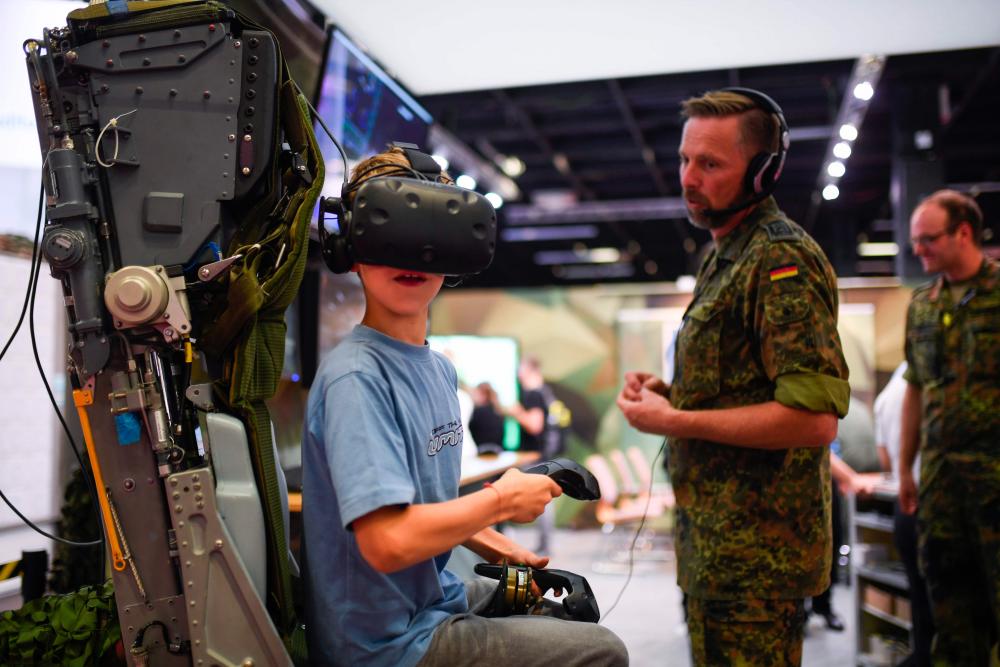A boy visits the German Armed Forces Bundeswehr stand during the Video games trade fair Gamescom in Cologne, Germany, on Aug 21, 2019. - AFP