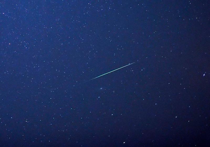 A falling star crosses the night sky over Halle / Saale, eastern Germany, during the peak in activity of the annual Perseids meteor shower on August 13, 2015. The Perseids meteor shower occurs every year when the Earth passes through the cloud of debris left by Comet Swift-Tuttle. AFP PHOTO / DPA / HENDRIK SCHMIDT