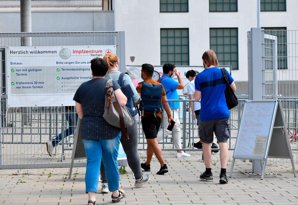 People line up to receive the vaccine against coronavirus disease (Covid-19) at a vaccination center at the Dresden Fair, in Dresden, Germany, July 29, 2021. — Reuters