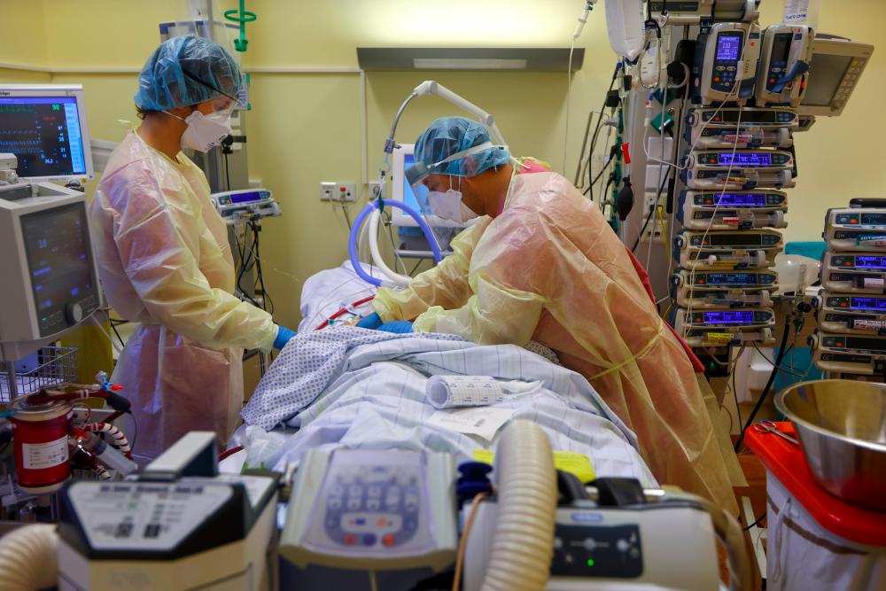 Members of the medical staff in protective suits treat a patient, on extracorporeal membrane oxygenation (ECMO) treatment, suffering from the coronavirus disease (Covid-19) in the Intensive Care Unit (ICU) at Havelhoehe Community Hospital in Berlin, Germany, December 6, 2021. REUTERSpix