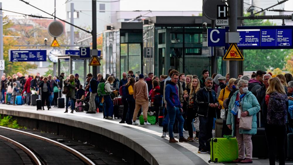 Rail passengers wait for a train on a platform at the main train station in Berlin on October 8, 2022 following major disruption on the German railway network. An act of sabotage targeting communications infrastructure was to blame for major disruption on the German railway network on Saturday, operator Deutsche Bahn said. - AFPPIX