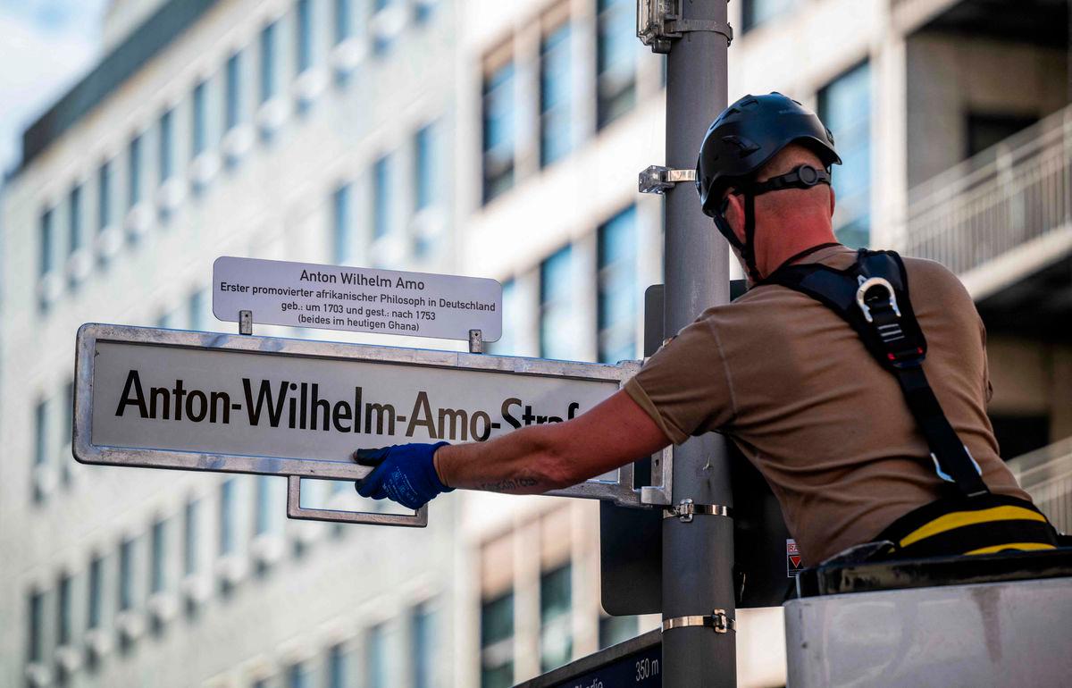A worker installs a street sign bearing what is supposed to become the new name for the ‘Mohrenstrasse’ (Moor street), the ‘Anton-Wilhelm-Amo-strasse’ in Berlin’s Mitte district on August 22, 2025. The street should have been renamed on August 23, 2025 as ‘Anton-Wilhelm-Amo-Straße’ to honor Anton Wilhelm Amo, a philosopher of African descent who became the first black scholar to receive a doctorate from a German university. (Photo by John MACDOUGALL / AFP)