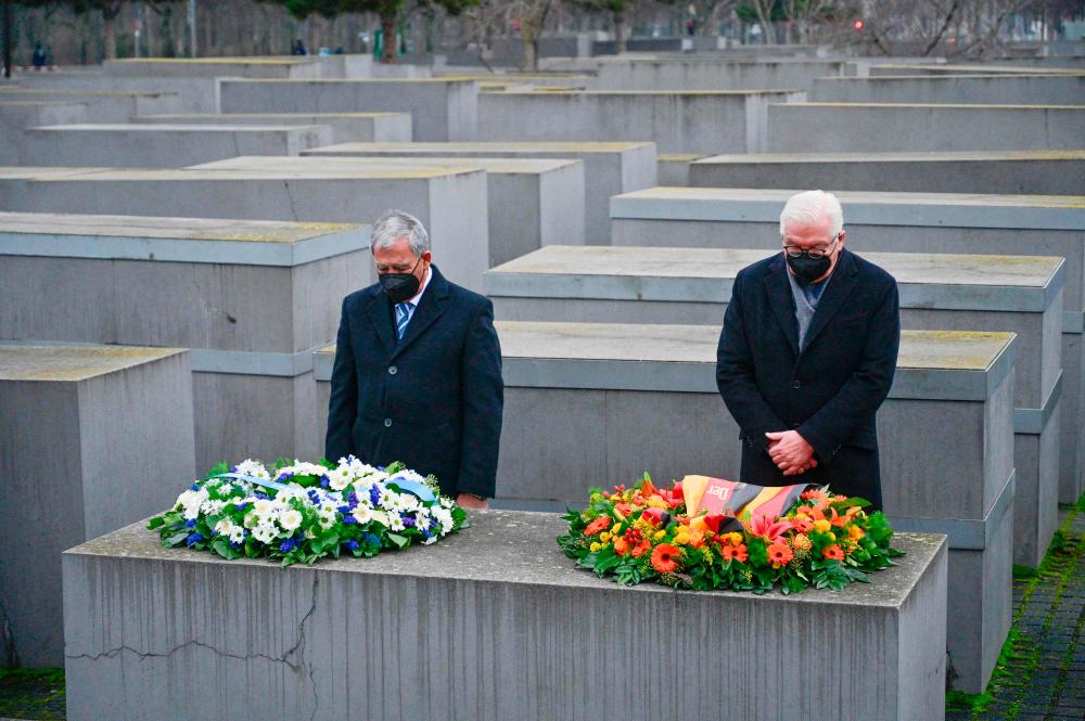 German President Frank-Walter Steinmeier (R) and the Speaker of Israel’s Knesset parliament Mickey Levy (L) arrange weraths on one of the concrete steles of Berlin’s Holocaust memorial, on January 27, 2022, as part of the ceremonies on the International Holocaust Remembrance Day. AFPPIX