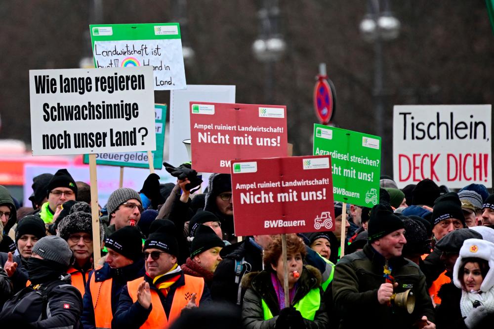 Demonstrators hold up placards during a protest of farmers and truck drivers in Berlin, Germany on January 15, 2024/AFPPix