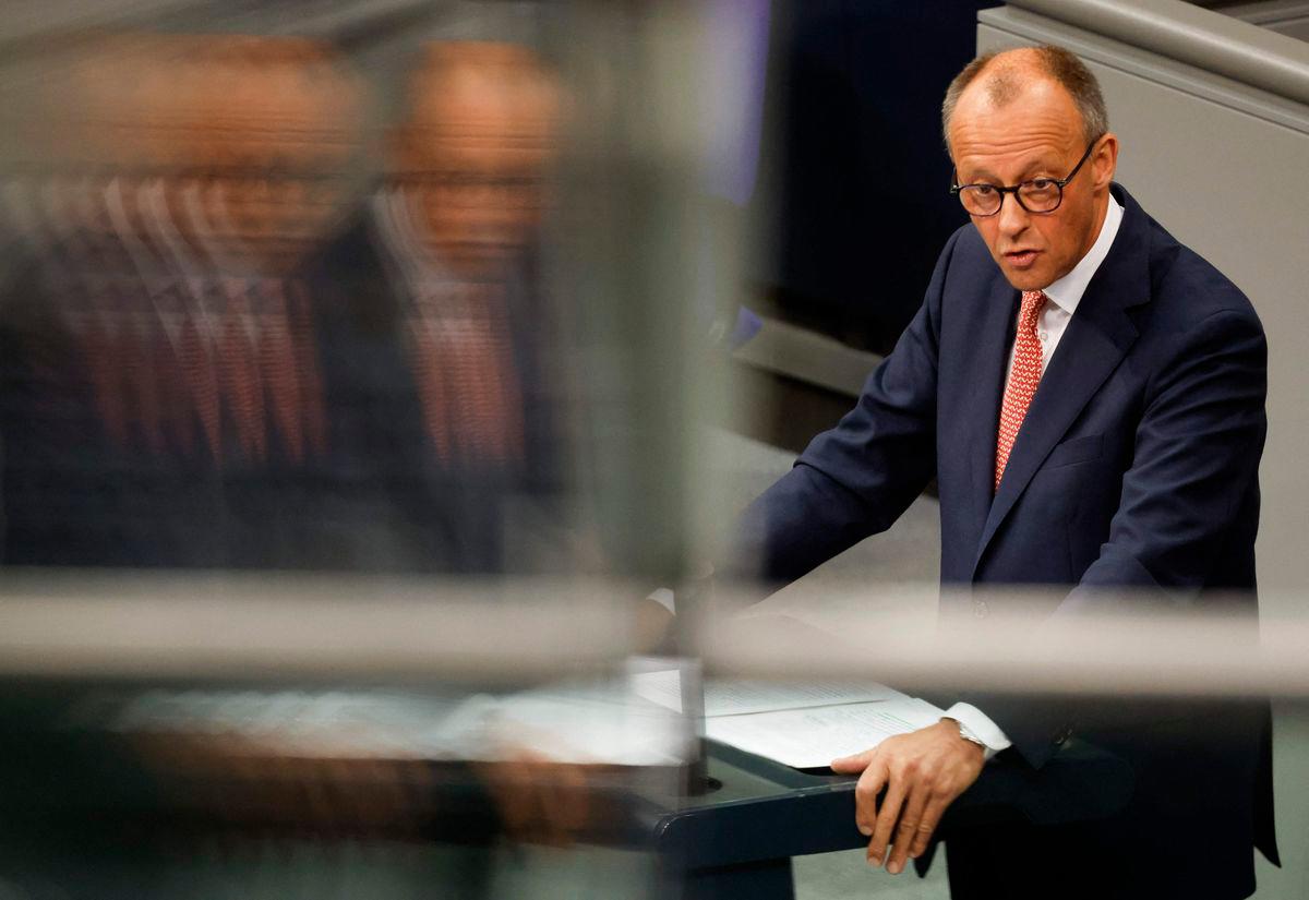German Chancellor Friedrich Merz is reflected as he gives a speech prior to a general debate on the budget of the Chancellery at the Bundestag, the lower house of parliament, in Berlin, on July 9, 2025. (Photo by Odd ANDERSEN / AFP)