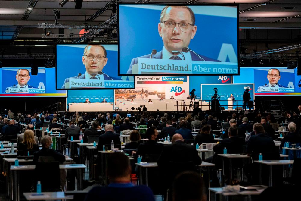 Alternative for Germany (AfD) party co-chairman Tino Chrupalla is seen on screens as he addresses delegates during a congress of far-right Alternative for Germany (AfD - Alternative fuer Deutschland) party in Dresden, eastern Germany, on April 10, 2021.-AFP