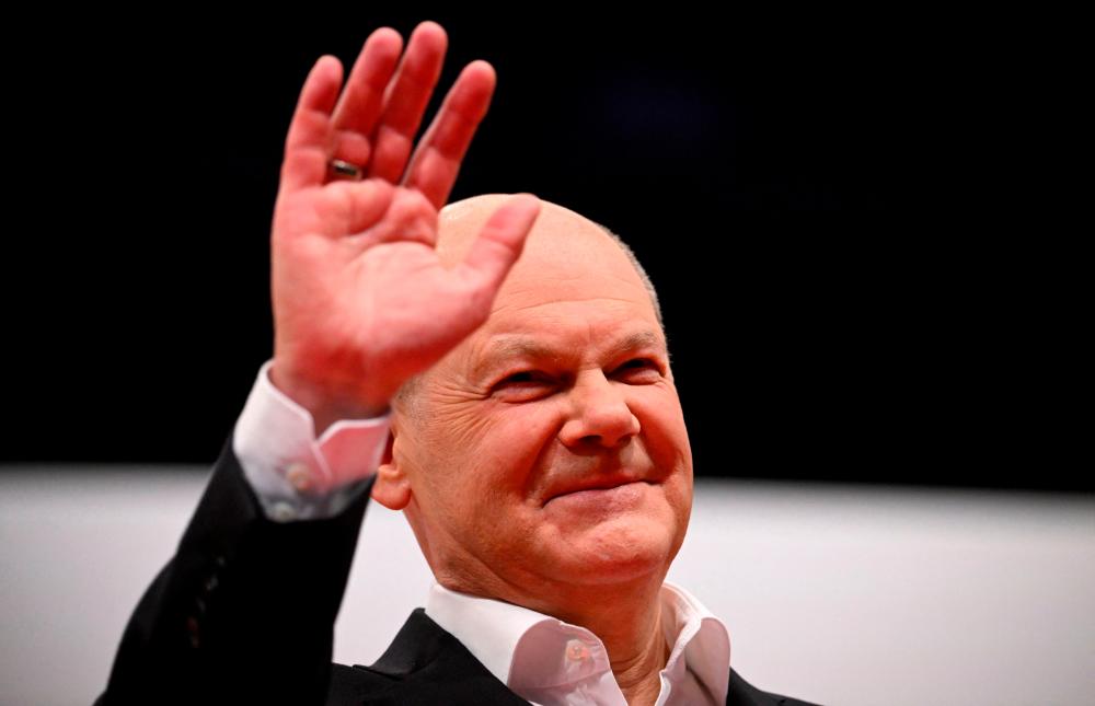 German Chancellor Olaf Scholz waves after giving a speech during the party congress of his social democratic SPD party in Berlin on December 9, 2023./AFPPix