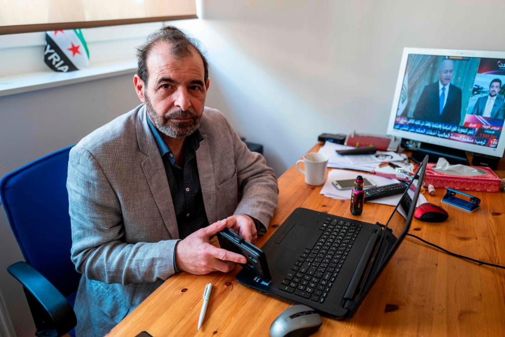 Syrian human rights lawyer Anwar al-Bunni poses in his office in Berlin on April 9, 2020. When Anwar al-Bunni crossed paths with fellow Syrian Anwar Raslan in a DIY store in Germany five years ago, he recognised him as the man who had thrown him into prison around a decade earlier. On Thursday, April 23, 2020 the two men will face each other in a German court, where Raslan will be one of two alleged former Syrian intelligence officers in the dock accused of carrying out crimes against humanity for Bashar al-Assad's regime. — AFP