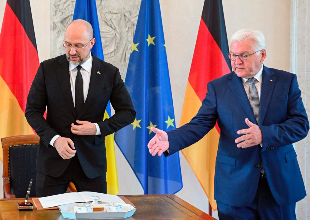 German President Frank-Walter Steinmeier (R) shows the guest book to Ukraine's Prime Minister Denys Shmyhal at the presidential Bellevue Palace in Berlin on September 4, 2022. - AFPPIX