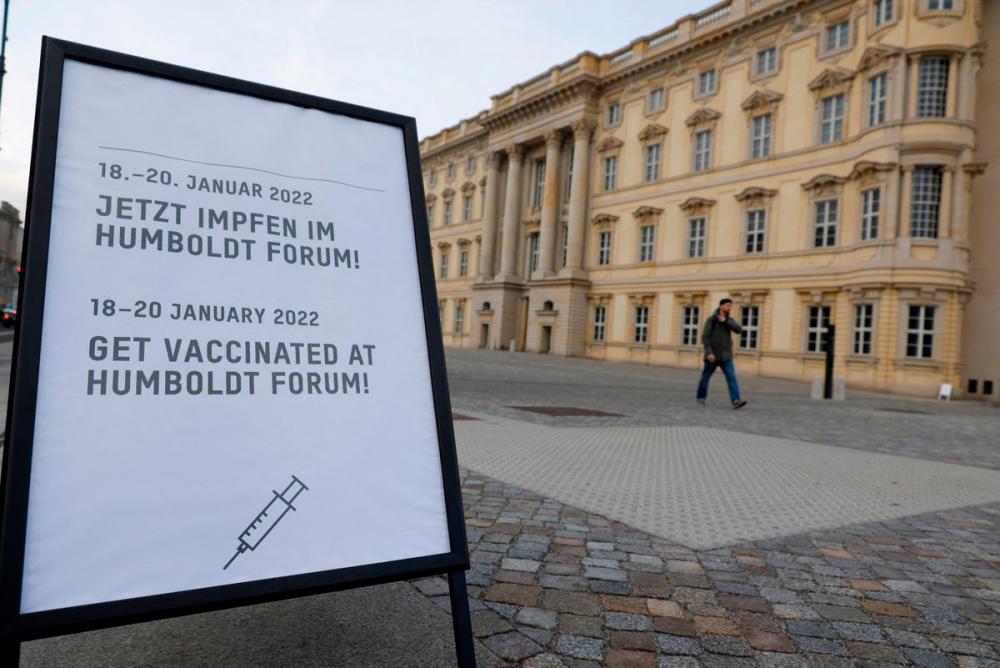 A sign displaying the dates that a pop-up vaccination centre is open is seen, as a person walks outside the coronavirus disease (Covid-19) vaccination centre in the Humboldt Forum, in Berlin, Germany January 19, 2022. REUTERSpix