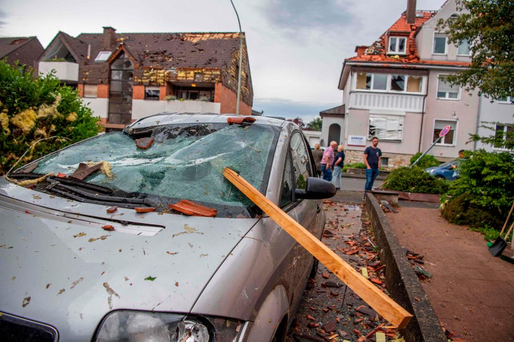 A roof batten is stuck in the windshield of a parked car in Paderborn, western Germany on May 20, 2022, after a storm also caused major damage. More than 30 people were injured, “including ten seriously” in Paderborn, a town in western Germany which was crossed by a “tornado”. AFPPIX