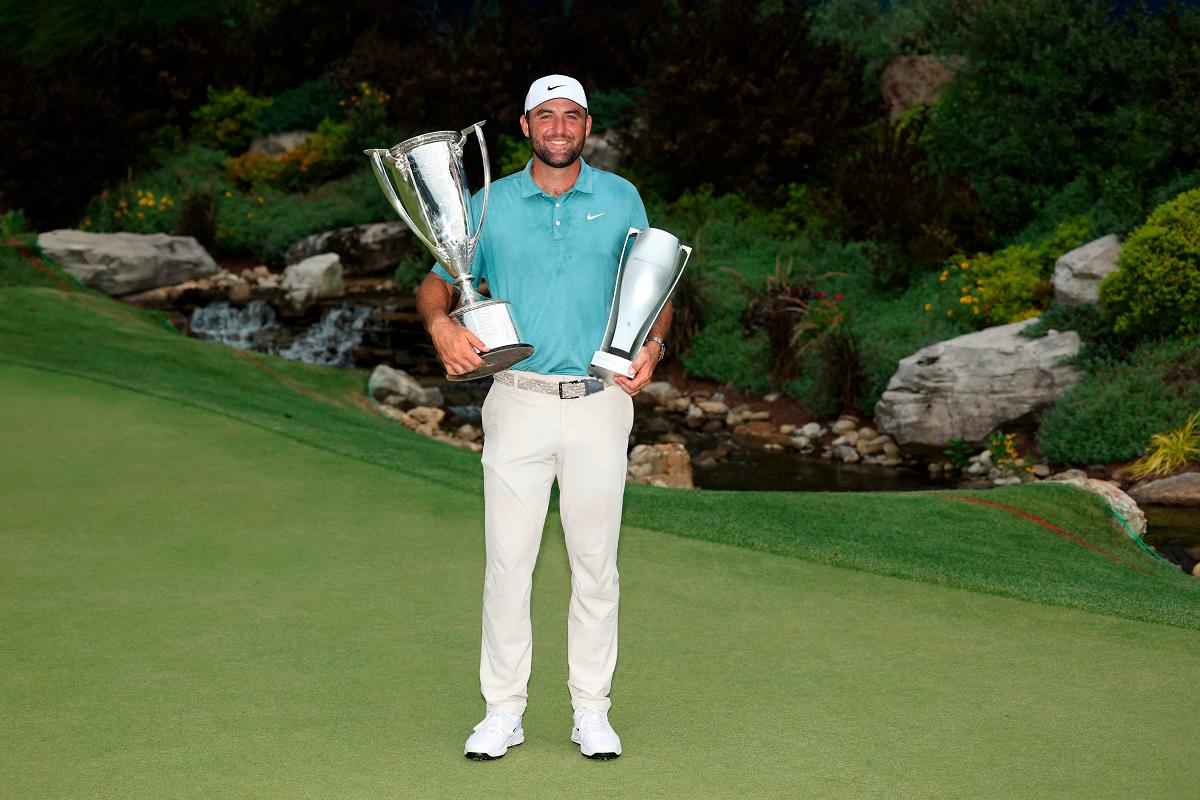Scottie Scheffler of the United States poses with the Western Golf Association (WGA) Open J.K. Wadley Championship Cup trophy and the tournament trophy after the final round of the BMW Championship 2025. -Kevin C. Cox/Getty Images/AFP