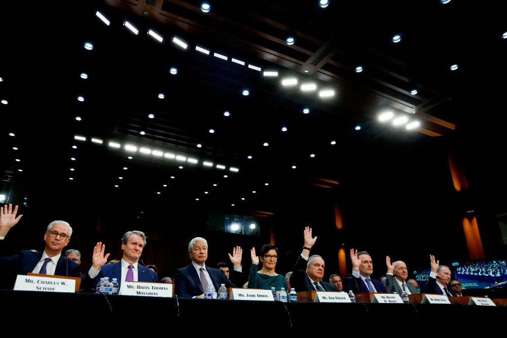 From left: Scharf, Moynihan, Dimon, Fraser, O'Hanley, Vince, Solomon and Gorman raise their hands during a US Senate Banking, Housing and Urban Affairs Committee oversight hearing on Wall Street firms, on Capitol Hill in Washington on Wednesday. – Reuterspic