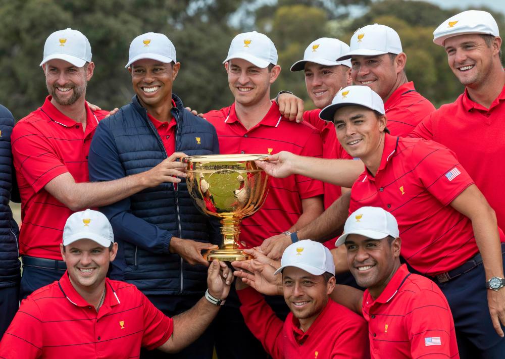 US team captain Tiger Woods (top row, 2nd L) and his teammates pose with the Presidents Cup after their win over the International Team on the final day of the Presidents Cup golf tournament in Melbourne on Dec 15, 2019. - AFP