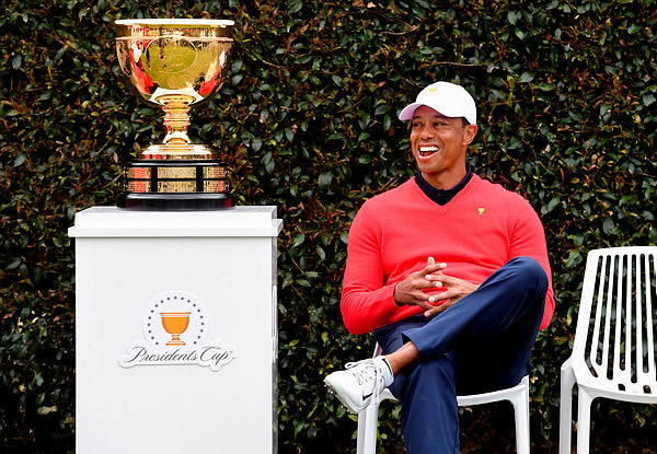 US team captain Tiger Woods looks at the trophy as he waits for his teammates for a team photo ahead of the Presidents Cup golf tournament starting on Dec 12, in Melbourne on Dec 11, 2019 — AFP