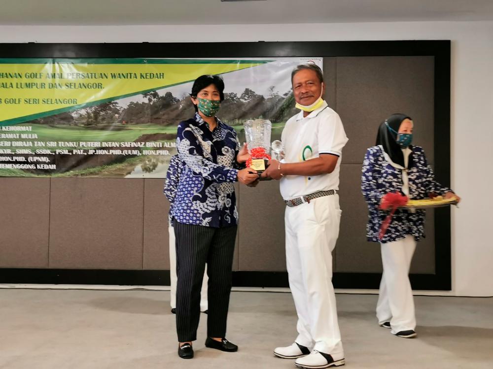 Tunku Puteri Intan Safinaz presents the trophy to the Gross Winner, Datuk Ahmad Ismail.