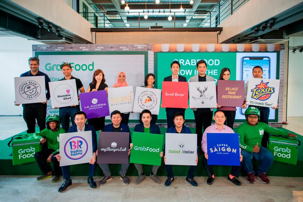 Goh (seated, in the middle) with GrabFood merchant partners.