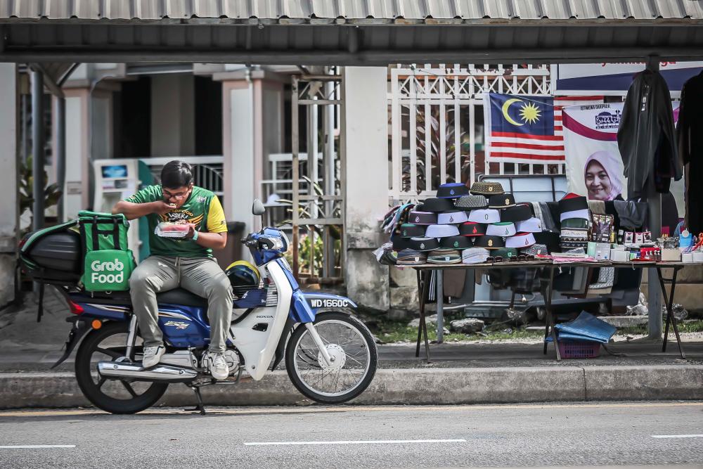 $!He prefer to have his meal on his only medium of transportation and his bestfriend, the blue motorcycle. - ADIB RAWI YAHYA/THESUN