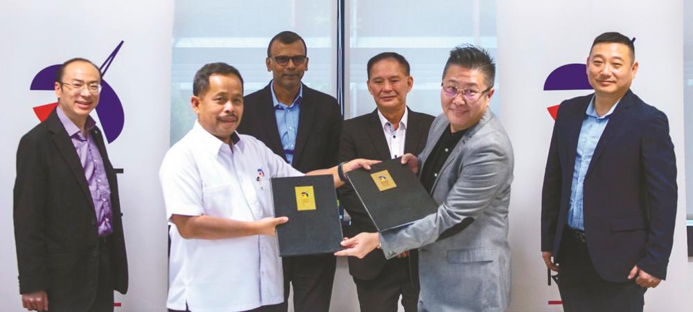 Baidzawi (front left) and Graphjet Technology executive director Jay Aw showing the letter of offer documents. Looking on are from left ECERDC senior manager Chin Chok Li, COO Datuk Ragu Sampasivam, Lim and Graphjet Technology chief technology officer and chief science officer Liu Yu.