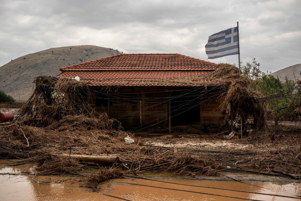 This photograph taken on September 26, 2023 shows a damaged house with the Greek national flag flying next it after the floodwater from Storm Daniel receded, in the village of Vlochos, central Greece/AFPPix