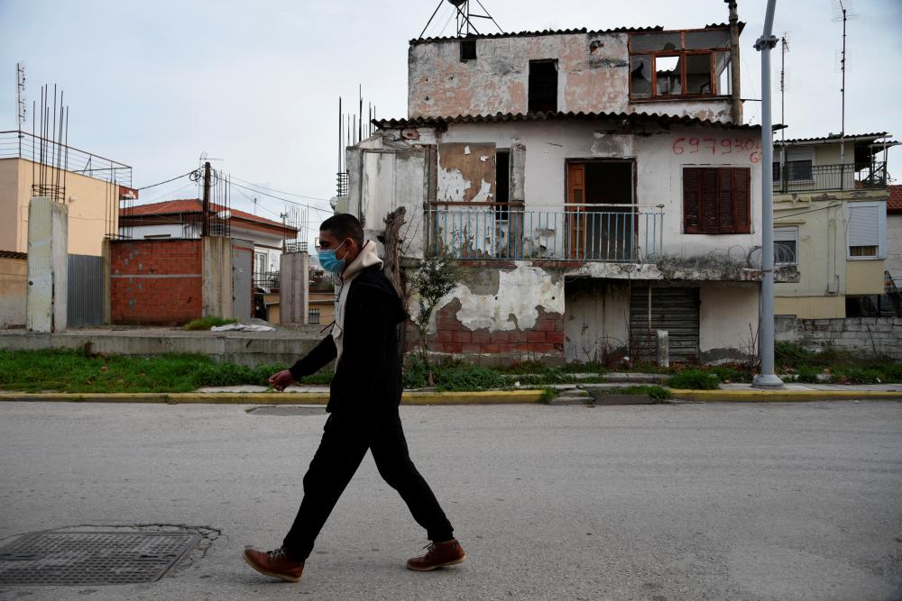 File photo: A man wearing a protective face mask against the coronavirus disease (Covid-19) walks in the neighbourhood of Dendropotamos, in Thessaloniki, Greece, January 7, 2022. REUTERSpix