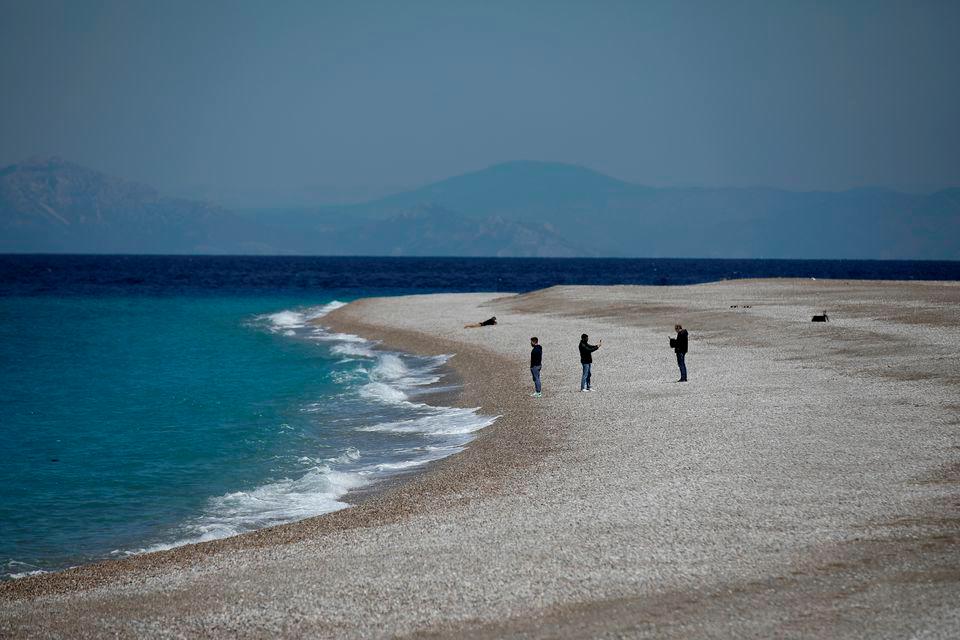 People stand on Elli Beach, amid the coronavirus disease (Covid-19) pandemic, on the island of Rhodes, Greece, April 12, 2021. — Reuters/File Photo