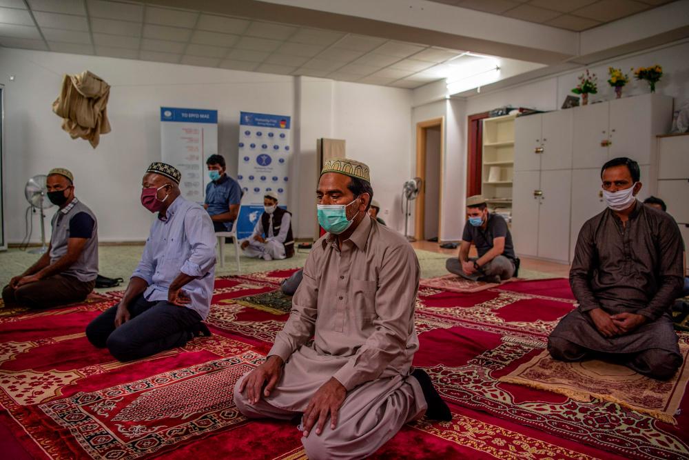 Muslims who live in Greece, wear protective face masks as they pray at a mosque in Athens on July 31, 2020. — AFP