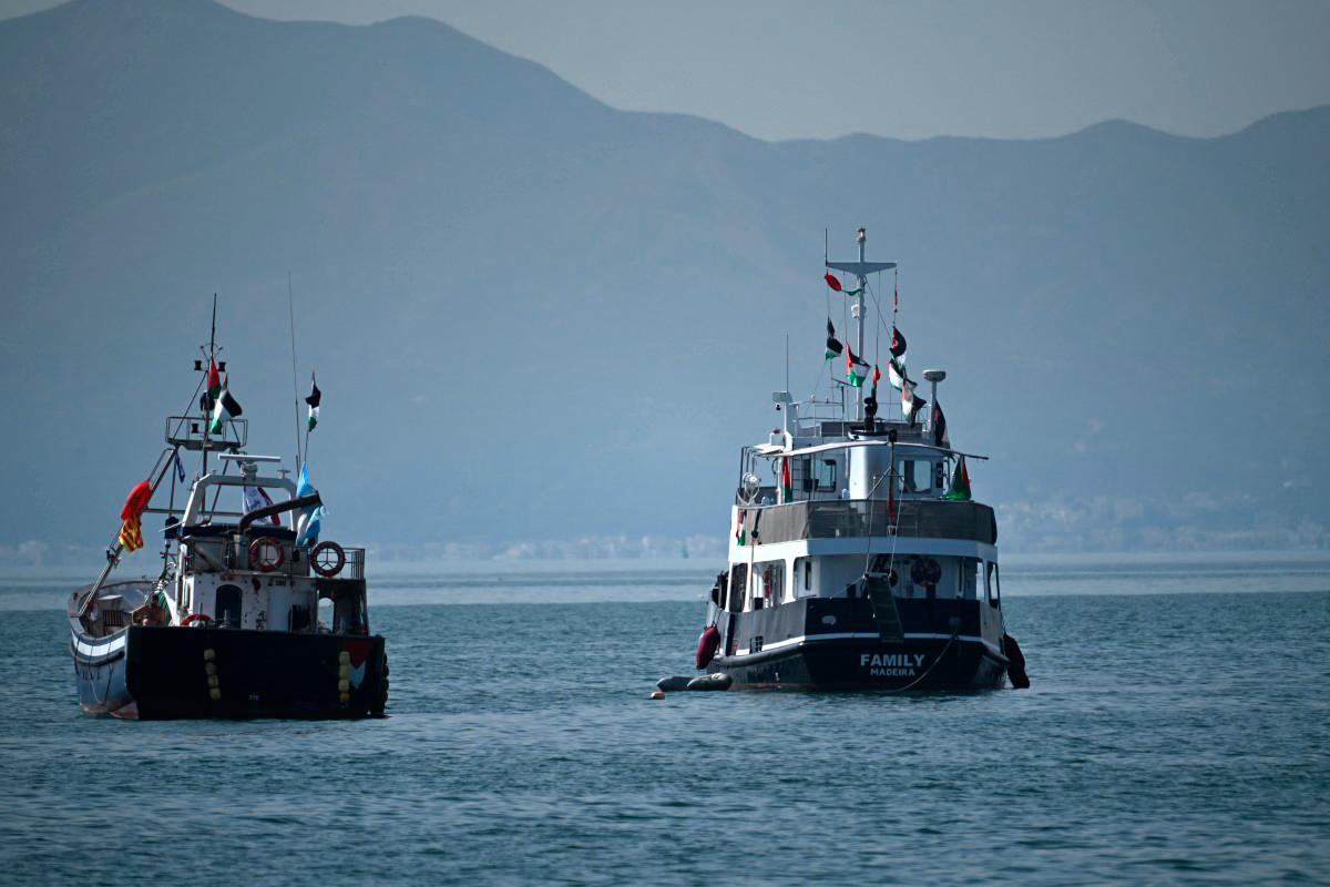 A ship (R), known as the Family and is part of the Global Sumud Flotilla, is anchored off the coast of the village of Sidi Bou Said on September 9, 2025. - FETHI BELAID / AFP