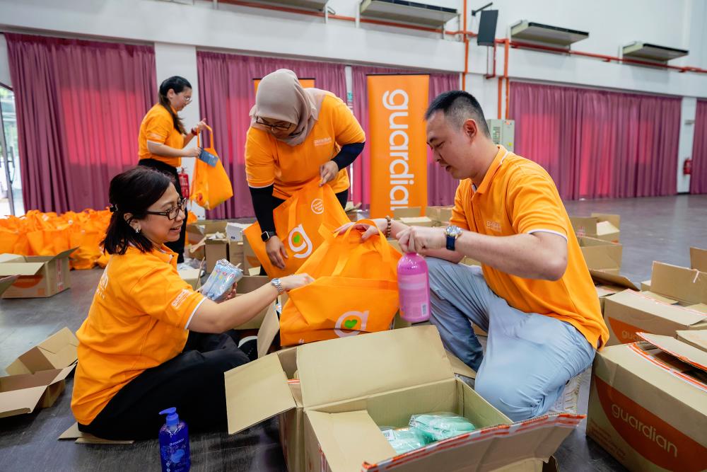 $!Guardian Malaysia volunteers packing flood aid items for distribution.