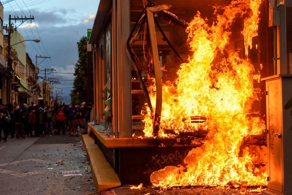 View of a bus stop set on fire during a protest demanding the resignation of Guatemalan President Alejandro Giammattei, in Guatemala City on November 21, 2020. — AFP