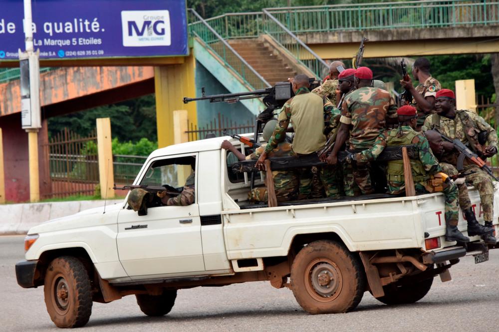 Members of the Armed Forces of Guinea drive through the central neighbourhood of Kaloum in Conakry on September 5, 2021 after sustainable gunfire was heard. — AFP